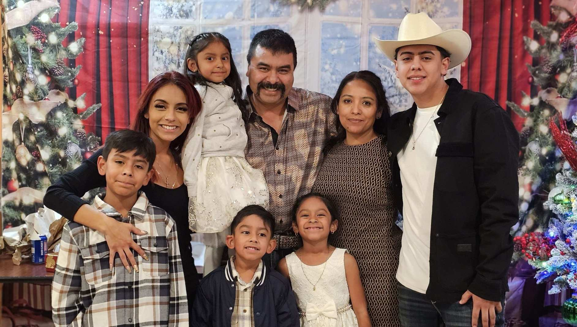 The Joaquín family smiling together in front of a decorated Christmas tree